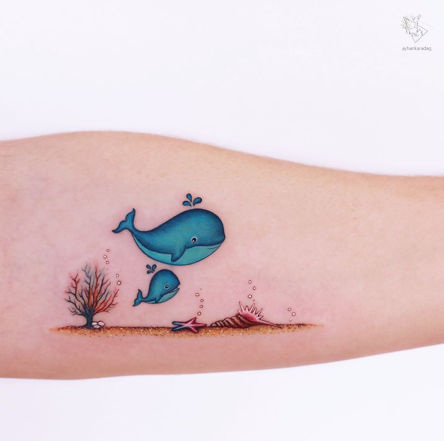 Tattoo design of blue whales swimming over seabed on human skin.