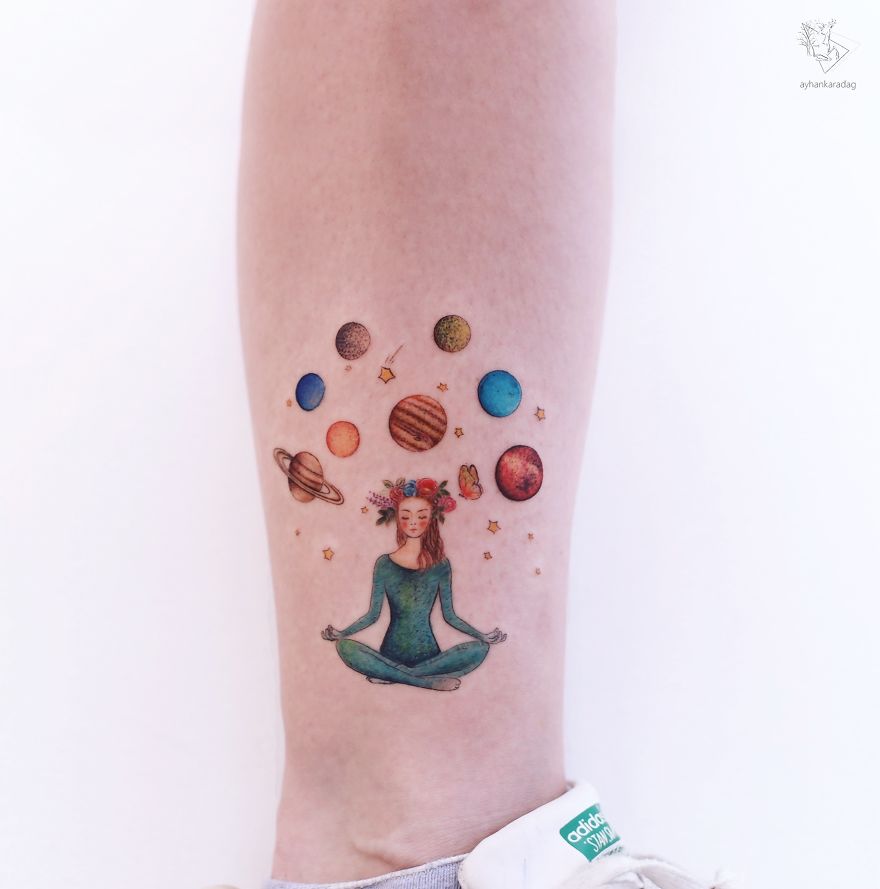 Colorful tattoo design featuring a meditative figure surrounded by planets on human skin.