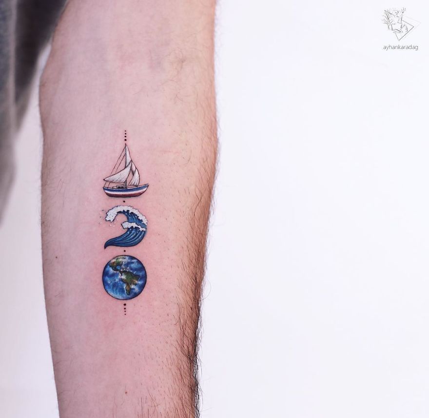 Tattoo design of a boat, wave, and Earth on forearm; detailed artwork on human skin.