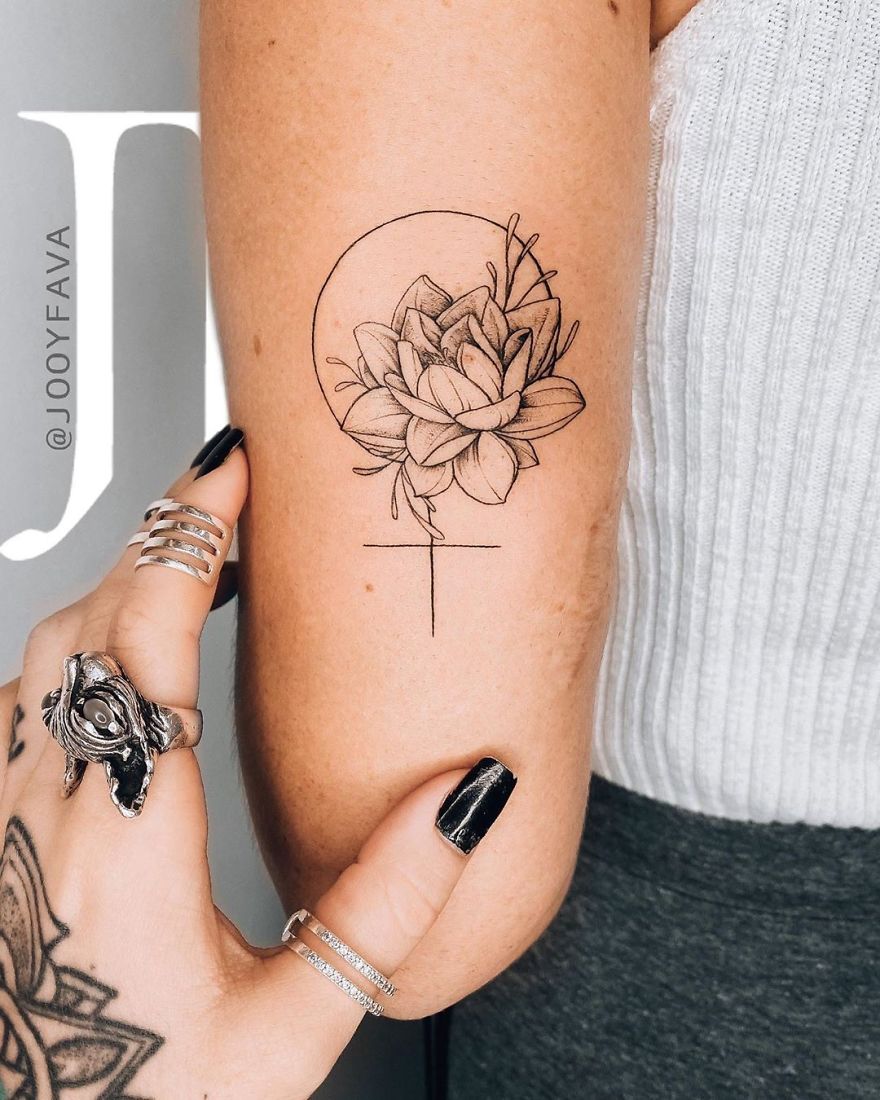 Elegant floral tattoo on an upper arm with delicate linework, exemplifying feminine tattoo art.