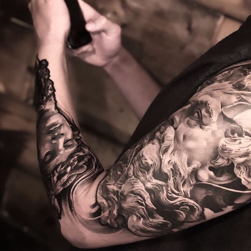 Arm with detailed masculine tattoo showing a classical artistic design.