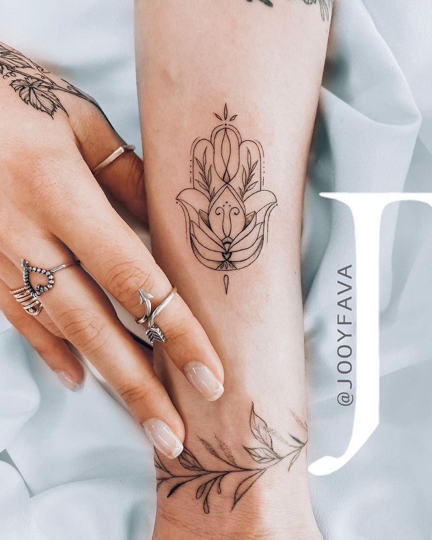 Elegant feminine tattoo design on forearm, featuring intricate floral and geometric patterns.