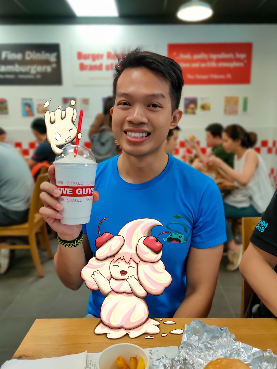 Person enjoying a milkshake with illustrated Pokémon characters in a restaurant setting.