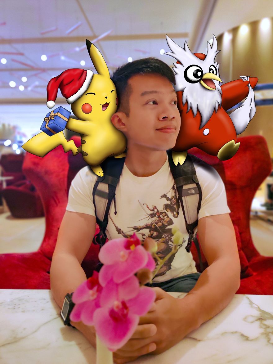 Man at a table with cartoon Pokémon characters on his shoulders, featuring a festive Pikachu and Delibird.