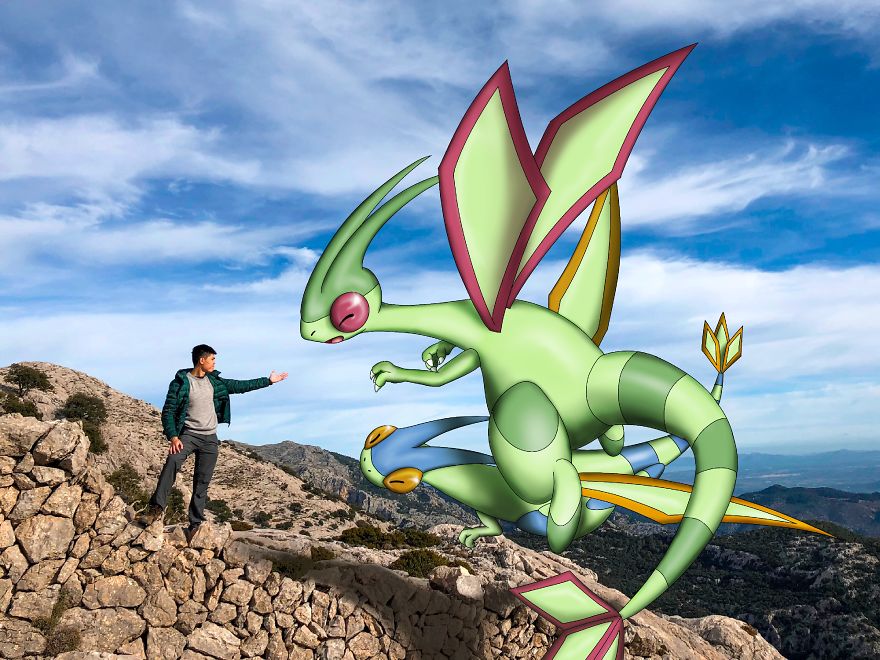 Person interacts with Pokémon illustration on a rocky landscape under a blue sky.
