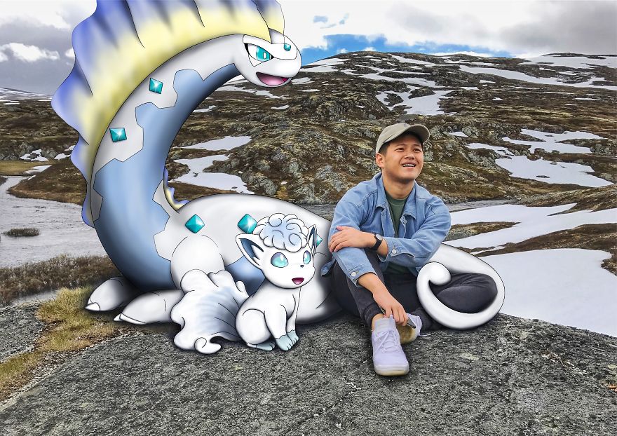 Man sitting next to Pokémon illustrations on a rocky landscape, featuring snowy hills in the background.