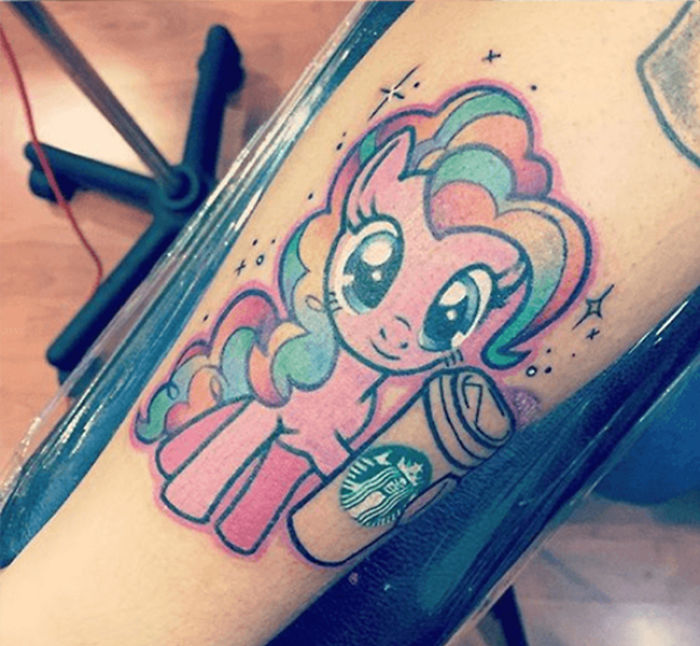 Colorful pony tattoo with a Starbucks cup on an arm.