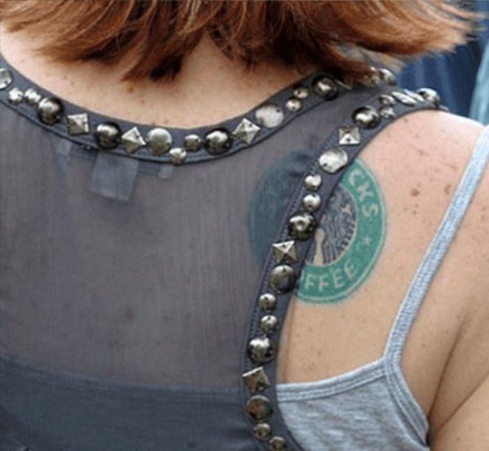 Person with Starbucks tattoo on the shoulder, wearing a studded top.