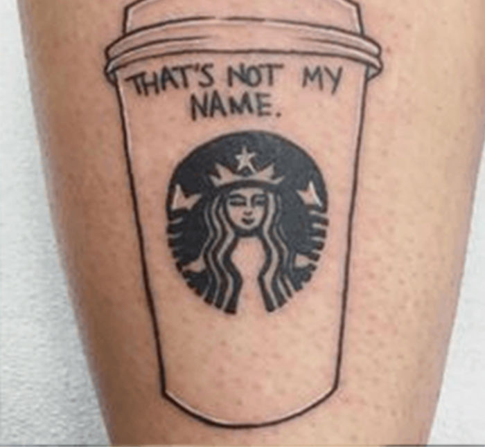 Starbucks tattoo featuring cup design and logo with the phrase "That's not my name" on skin.