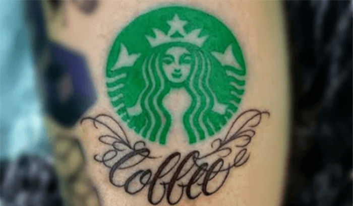 Starbucks logo tattoo with "coffee" text inked underneath on forearm.