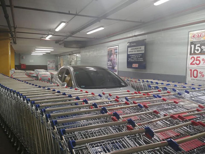 Car surrounded by multiple shopping carts 