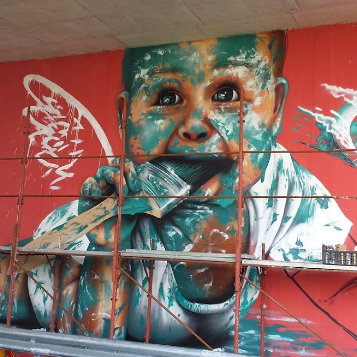 3D street art mural of a child with a paintbrush, blending vibrant colors and interacting with construction scaffolding.