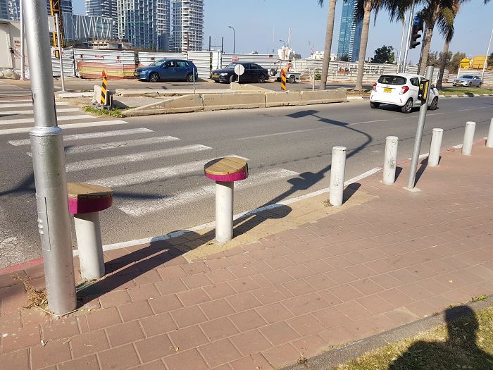 These Wooden Circular Tops For Pedestrians To Sit On While Waiting For The Light To Change
