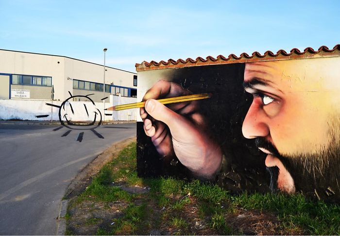 3D street art mural of a man drawing a sun with a pencil, blending seamlessly with the street and surroundings.