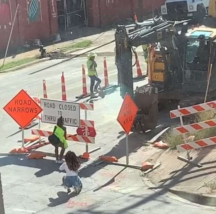 Woman taking a picture of a Woman posing near a construction site