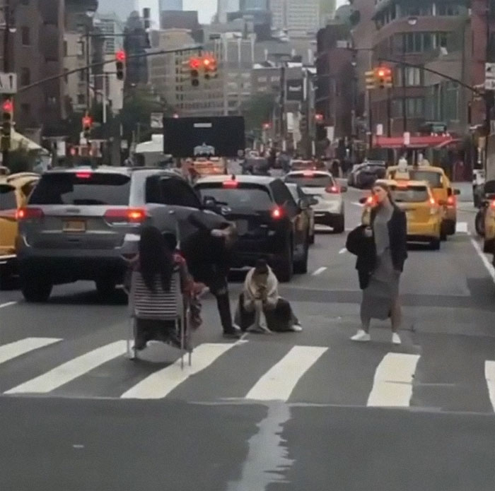 Multiple people posing and taking pictures on crosswalk