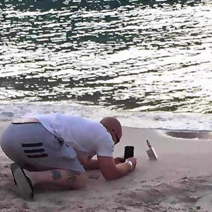 Man taking a picture of vape in a beach 
