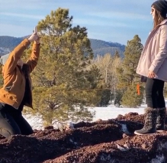 Man taking a picture of his wife on knees 