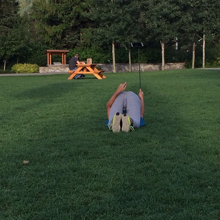 Man taking a picture while laying on the ground 