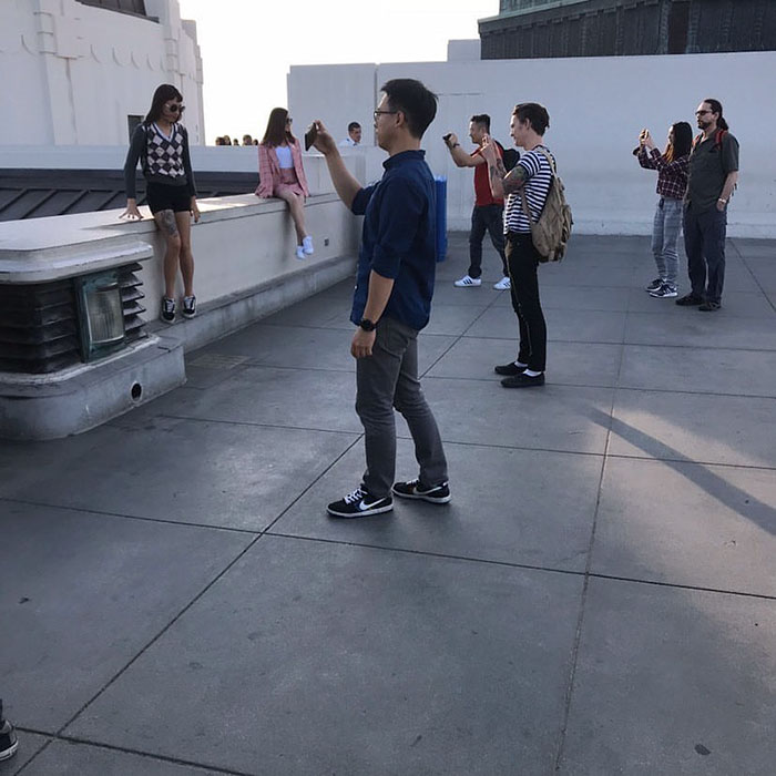 Multiple people taking pictures of their friends 