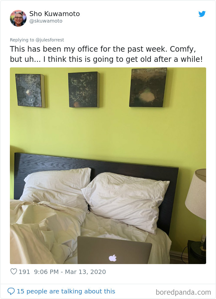 Bed with white pillows and laptop, showing a realistic working from home workspace setup with a simple background.