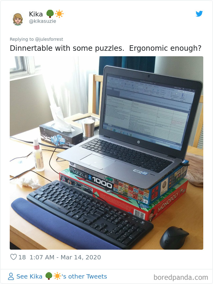 Laptop on puzzle and board game boxes as a makeshift desk setup showing reality of working from home.