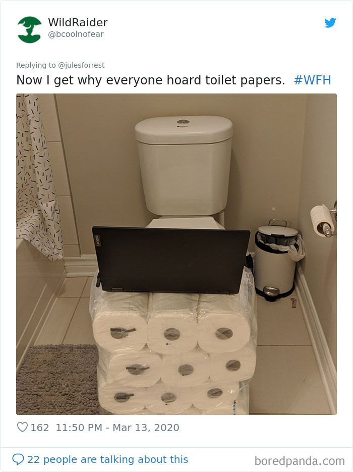 Laptop placed on stacked toilet paper rolls in a bathroom, showing the reality of working from home setups.