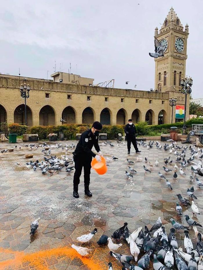 Policeman Feeding Birds Near Erbil Citadel During COVID-19. No One Else Is Out Due To The Pandemic