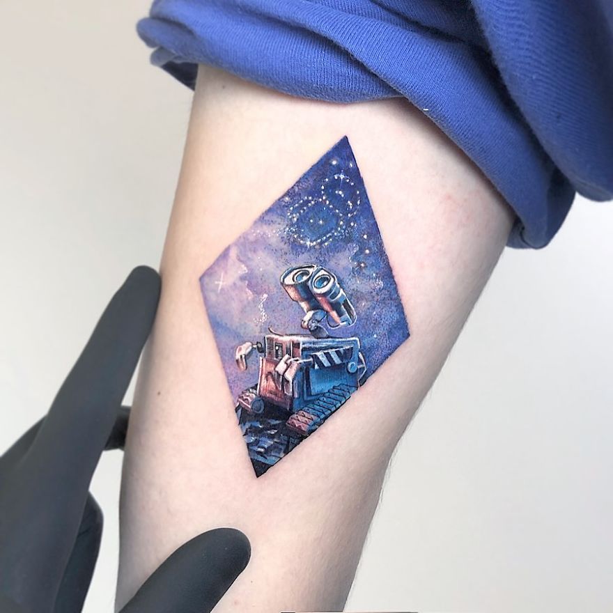 Colorful micro tattoo of a robot, resembling a mini pop culture painting, on a person's arm by Eden Kozokaro.