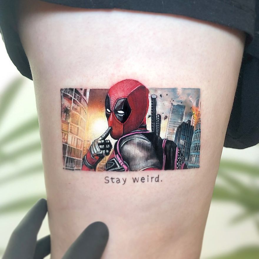 Colorful micro tattoo of a pop culture character by Eden Kozokaro with the phrase "Stay weird."