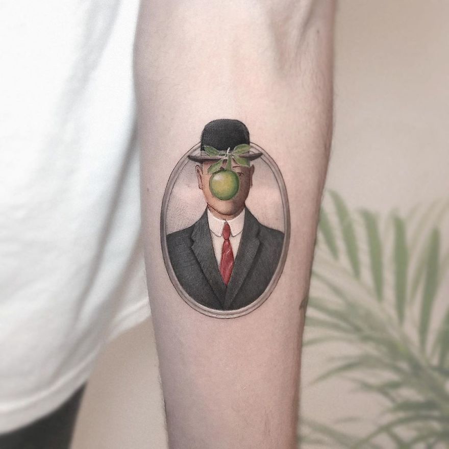 Colorful micro tattoo of a faceless man with an apple, inspired by pop culture, on a person's forearm.
