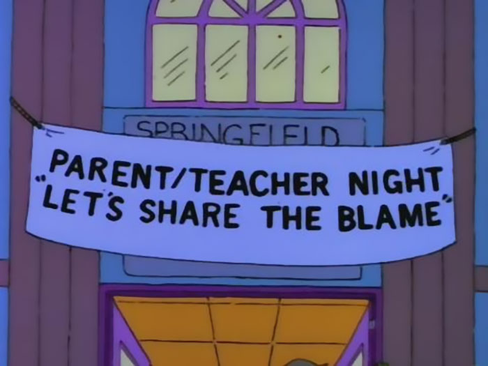 Sign in The Simpsons reading Parent/Teacher Night Let's Share The Blame, showcasing witty signs found in The Simpsons series.