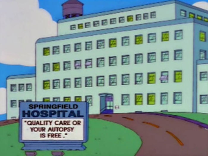Springfield Hospital building with a witty sign about quality care or free autopsy from The Simpsons.