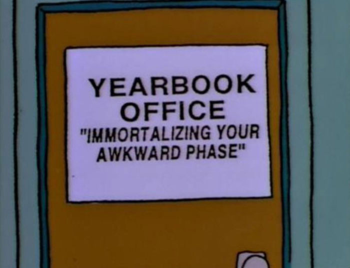 Sign on The Simpsons yearbook office door humorously reads immortalizing your awkward phase, showcasing witty Simpsons signs.
