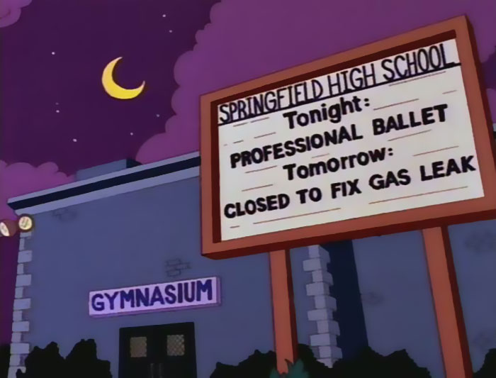 Sign at Springfield High School gymnasium showing witty message about a professional ballet and gas leak closure from The Simpsons.