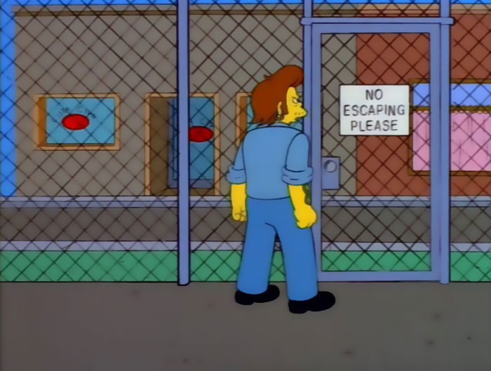 Character from The Simpsons looking at a sign that humorously reads no escaping please behind a chain link fence