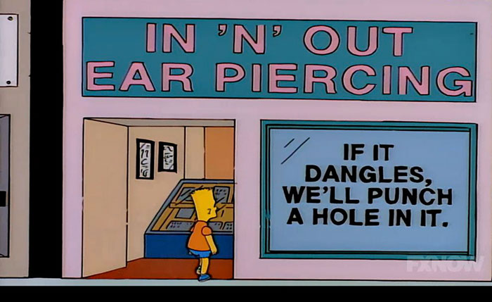 Bart Simpson looking at a witty sign at an ear piercing shop in the Simpsons featuring humorous wording.