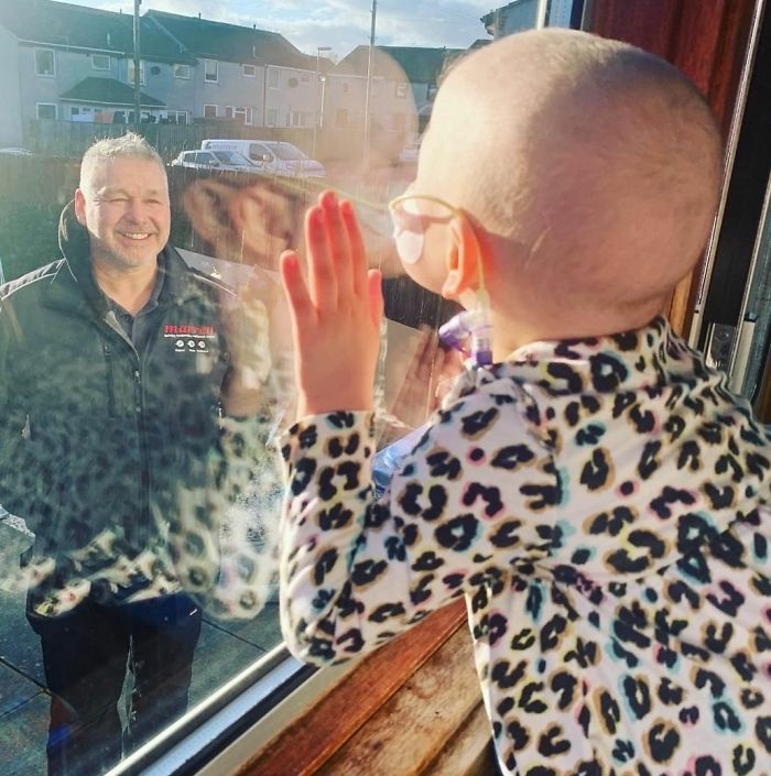 A Four-Year-Old Girl With Cancer Kissing Her Father Through A Window.