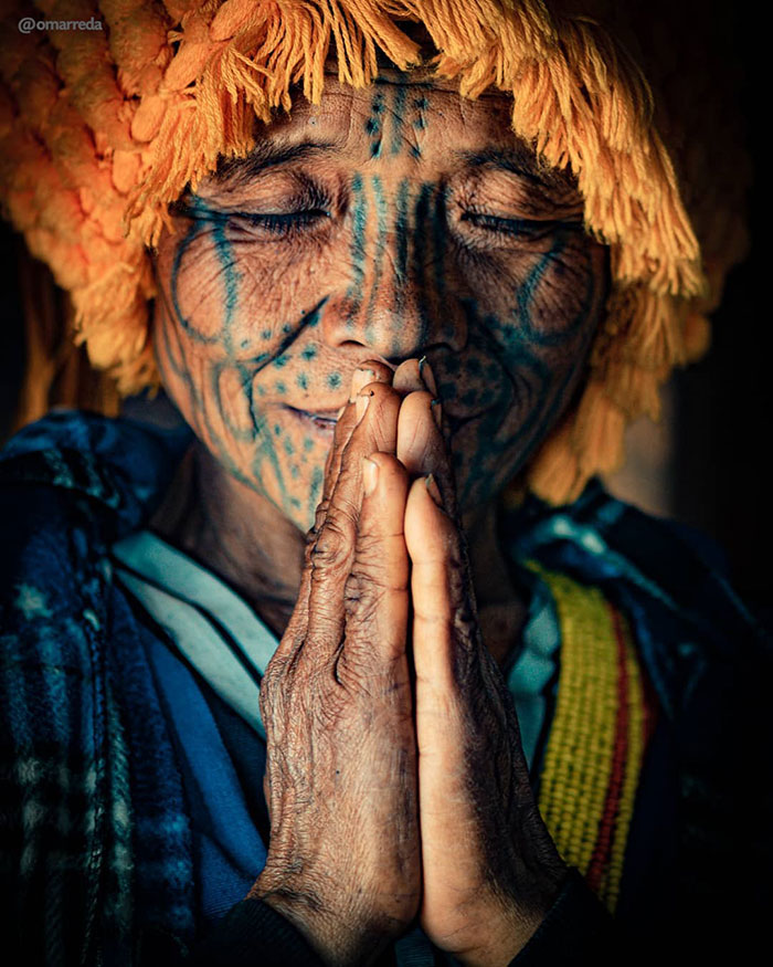 In The Photo, A Mon Woman Is Praying In A Small Church Made Out Of Wood