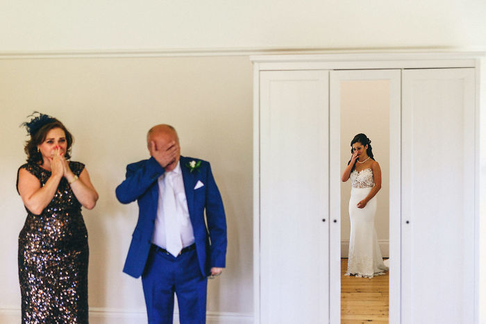 Father and daughter share an emotional, unstaged moment at a wedding, capturing genuine love and connection.