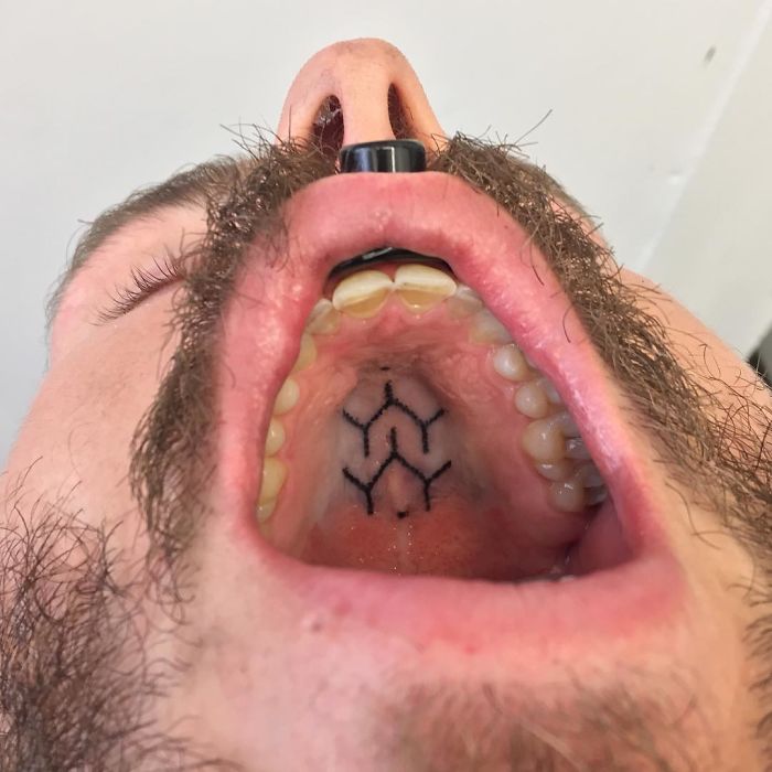 Tattoo artist's ink on the roof of a mouth, showcasing unconventional body art technique.