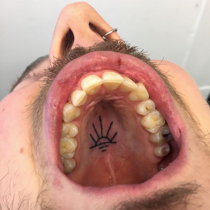 Tattoo inside mouth on roof, showcasing unconventional body art by tattoo artist.