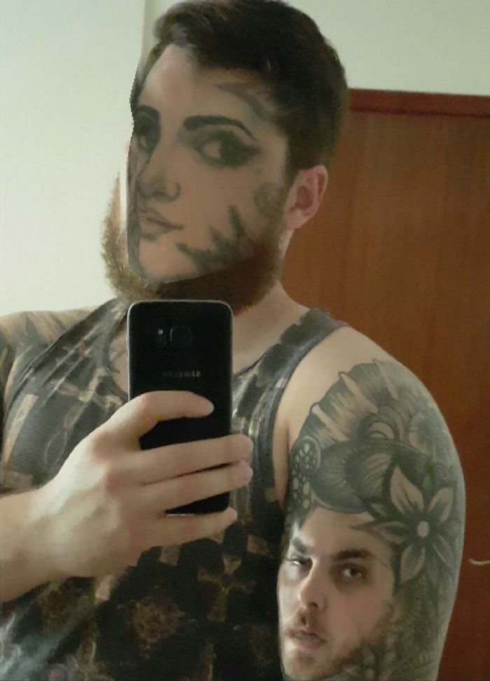 Man face swapping tattoos on body, selfie showing unsettling results.