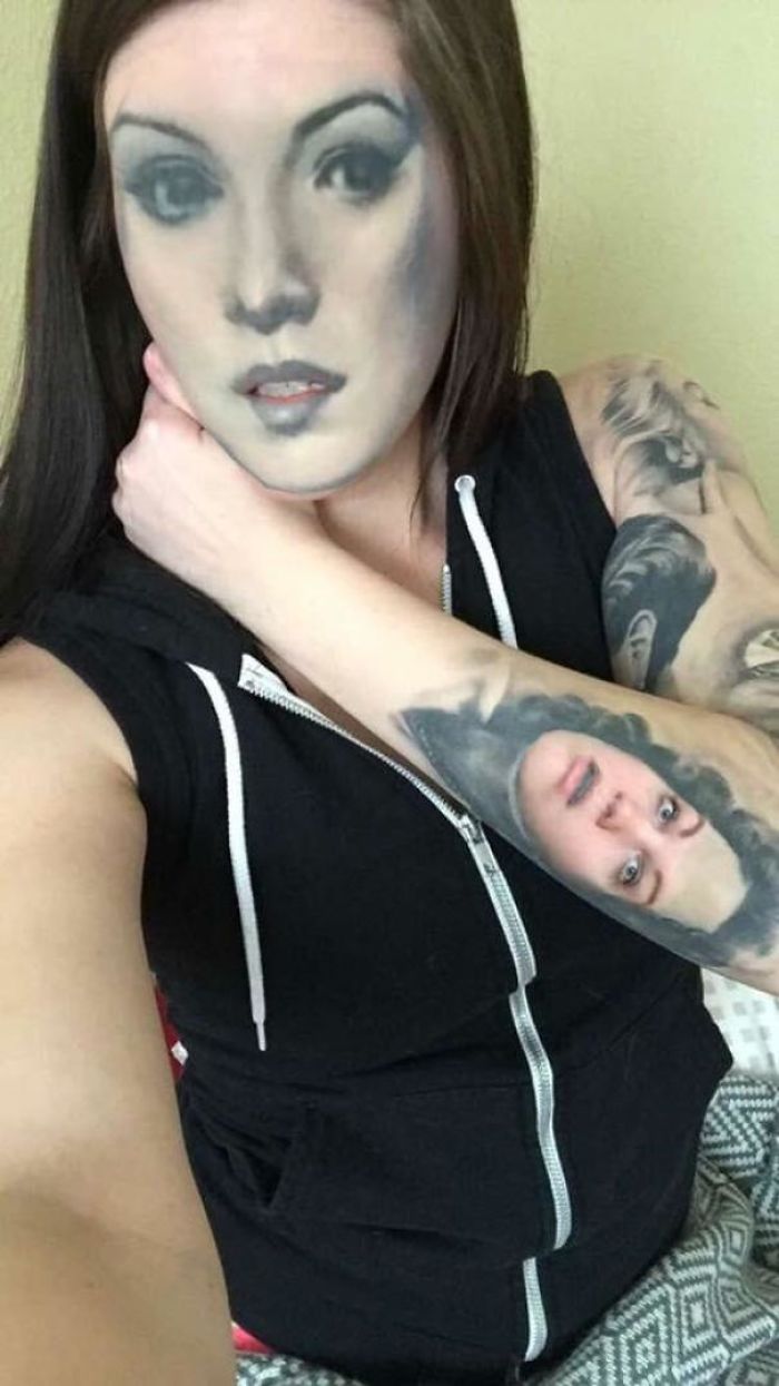 Person with face-swap tattoo on arm and swapped face, creating surreal art using face swapping techniques.