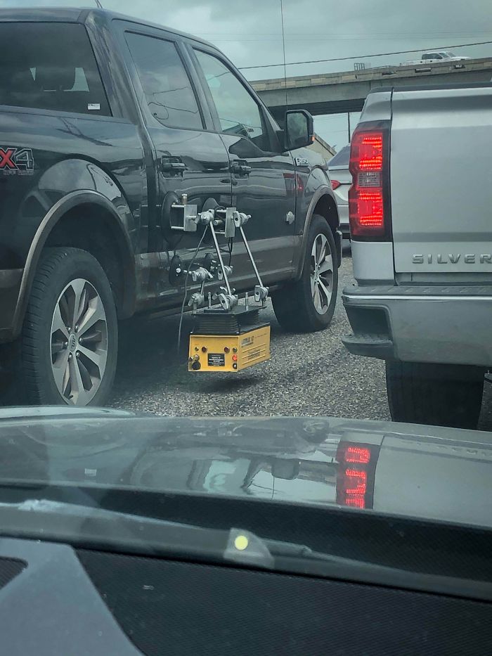 Saw This On The Side Of A Truck While Driving. Was Not Able To Get Close Enough To Read What Is Says. Yellow Box Hanging By Suction Cup With Wire To Back Of Box. Two Blinking Red Lights On It As Well