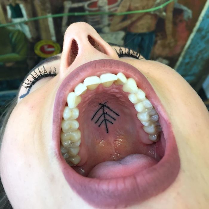 Tattoo inside the mouth, showcasing unconventional body art on the roof of the mouth.