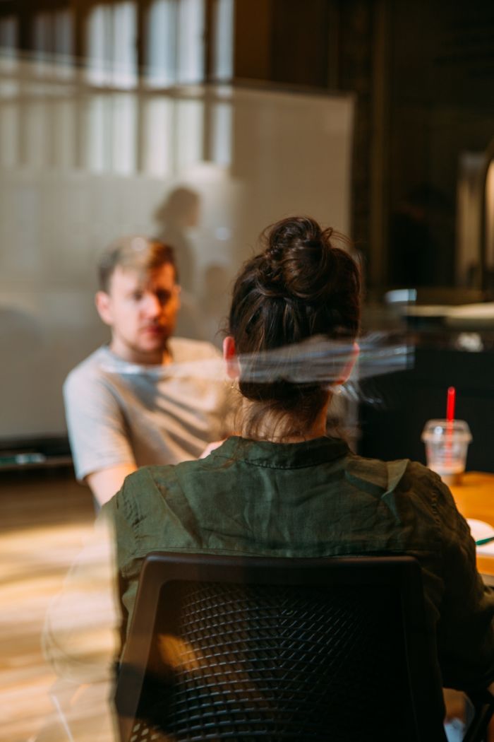 Two people in a modern office during a job interview, illustrating employers rejecting candidates right away.