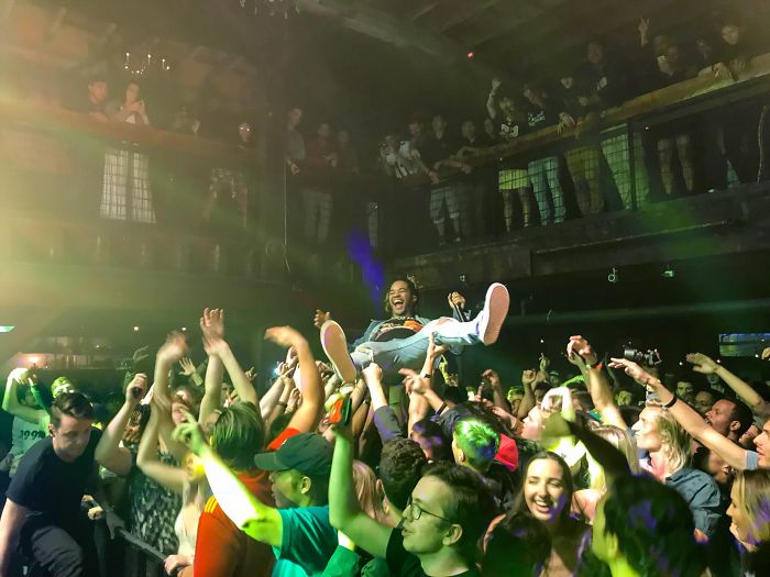 Crowd at a concert lifting a person up, illustrating energy and engagement, related to employers rejecting job candidates.