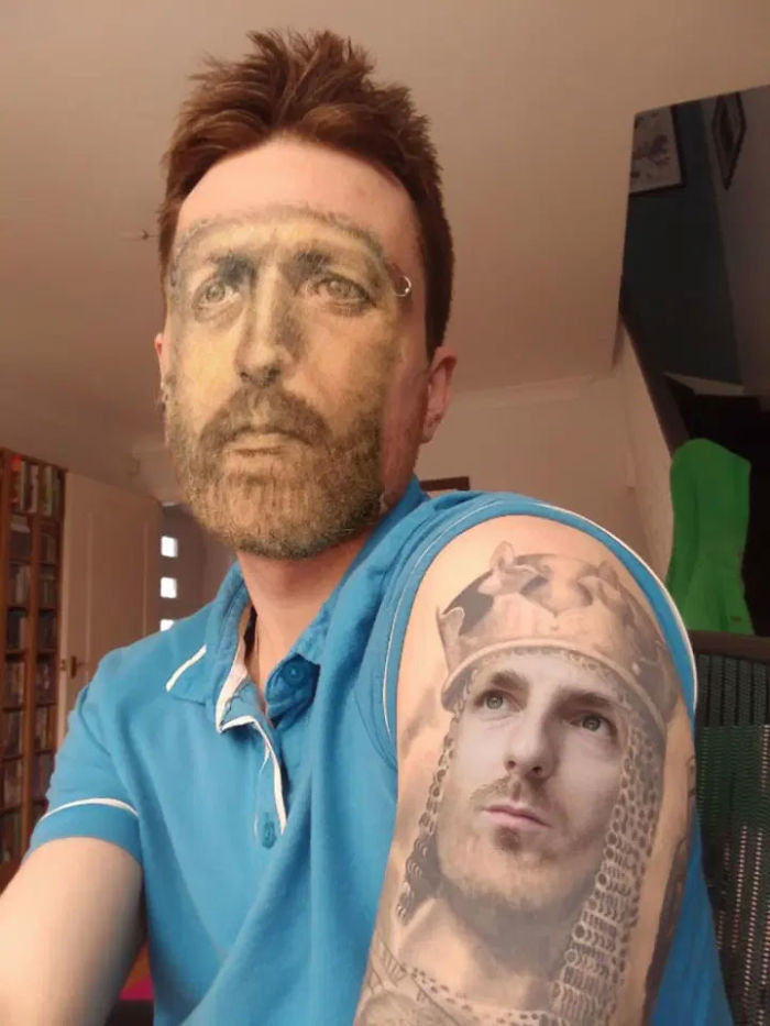 A person with a face swapped tattoo on their arm, wearing a blue shirt.