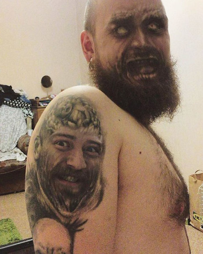 Bearded man with face swapped tattoos on shoulder, featuring unsettling facial expressions.